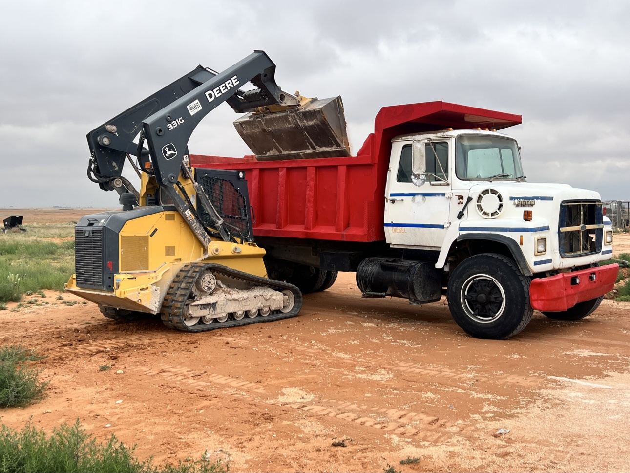 Skid steer loading a Can You Dig It dump truck