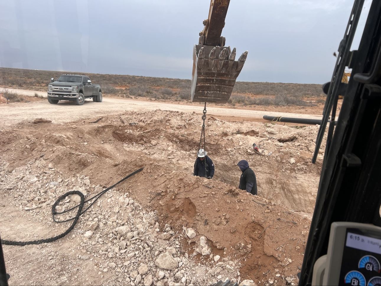 Crew performing flowline work in a trench